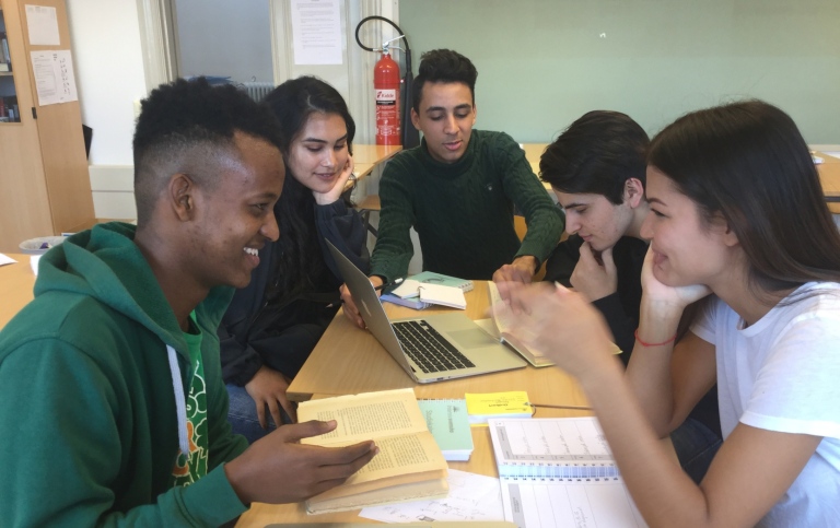 En grupp elever runt ett bord studerar tillsammans. Foto: Intensivsvenska